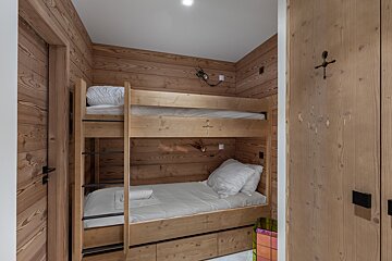 A bedroom with a painting on the wall above the bed