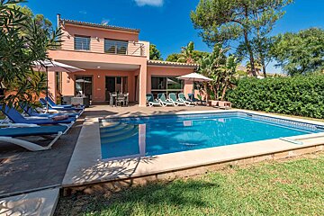 A house with a large swimming pool in front of it