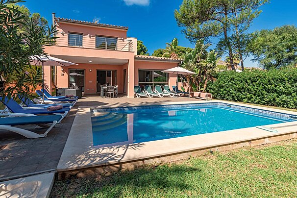 A house with a large swimming pool in front of it