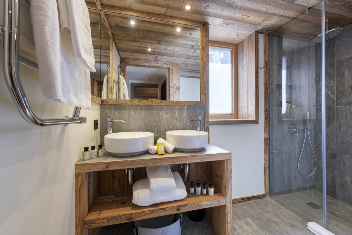 A bathroom with two sinks and a shower
