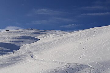 A snowy mountain with a blue sky in the background
