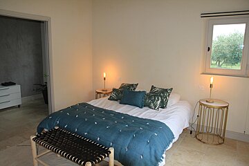 A bedroom with a blue blanket and pillows