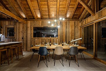 A wooden dining room with a table and chairs