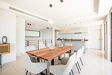 A dining room with a wooden table and white chairs