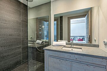 A bedroom with a bed and a television on the wall