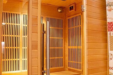 A wooden sauna with a curtain that has russian dolls on it