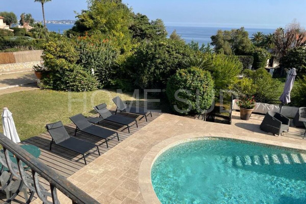 A swimming pool surrounded by chairs and umbrellas with the word home visible in the background