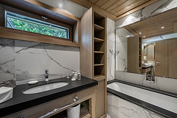 A bathroom with a sink and a tub and a window