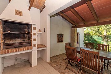 A patio with a table and chairs and a grill