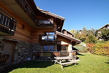 A wooden house with a picnic table in front of it