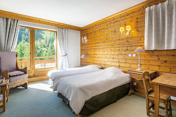 A hotel room with two beds and a desk