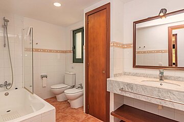 A bathroom with two toilets and a sink