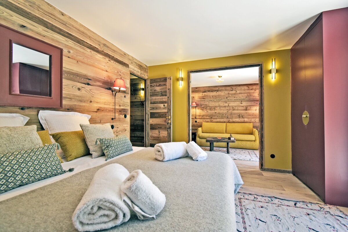 A bedroom with a wooden wall and a yellow couch