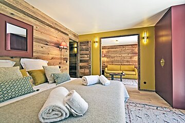 A bedroom with a wooden wall and a yellow couch