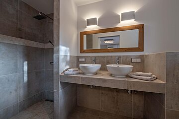 A bathroom with two sinks and a large mirror