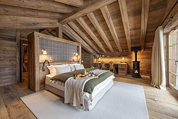 A bedroom with a tray of food on the bed