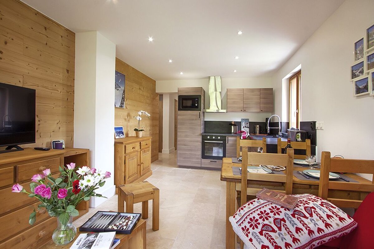 A living room with a table and chairs and a tv
