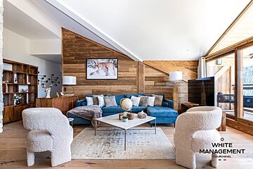 A living room with a blue couch and a flat screen tv