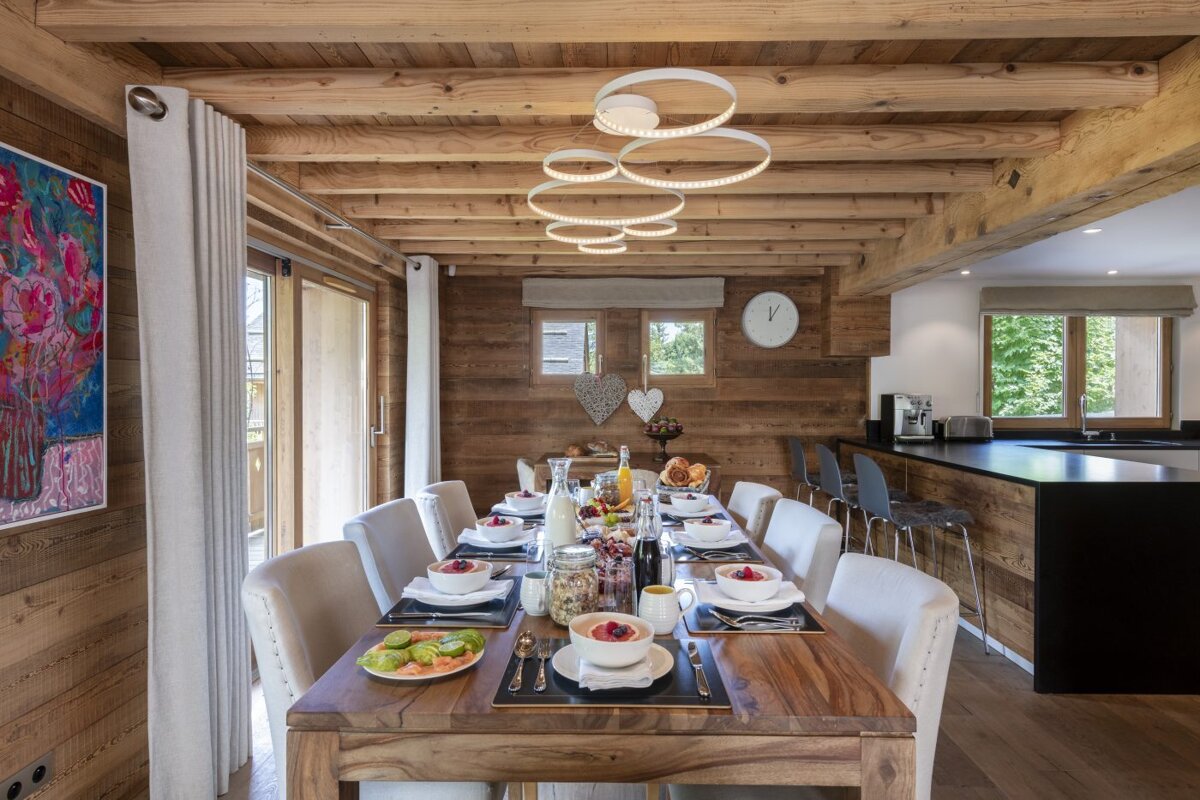 A wooden dining room table with plates of food on it
