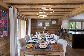 A wooden dining room table with plates of food on it