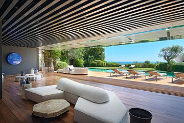A living room with a swimming pool in the background