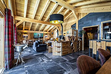 A living room with a black lamp hanging from the ceiling