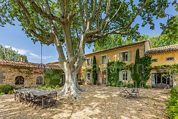 A large house with a large tree in front of it