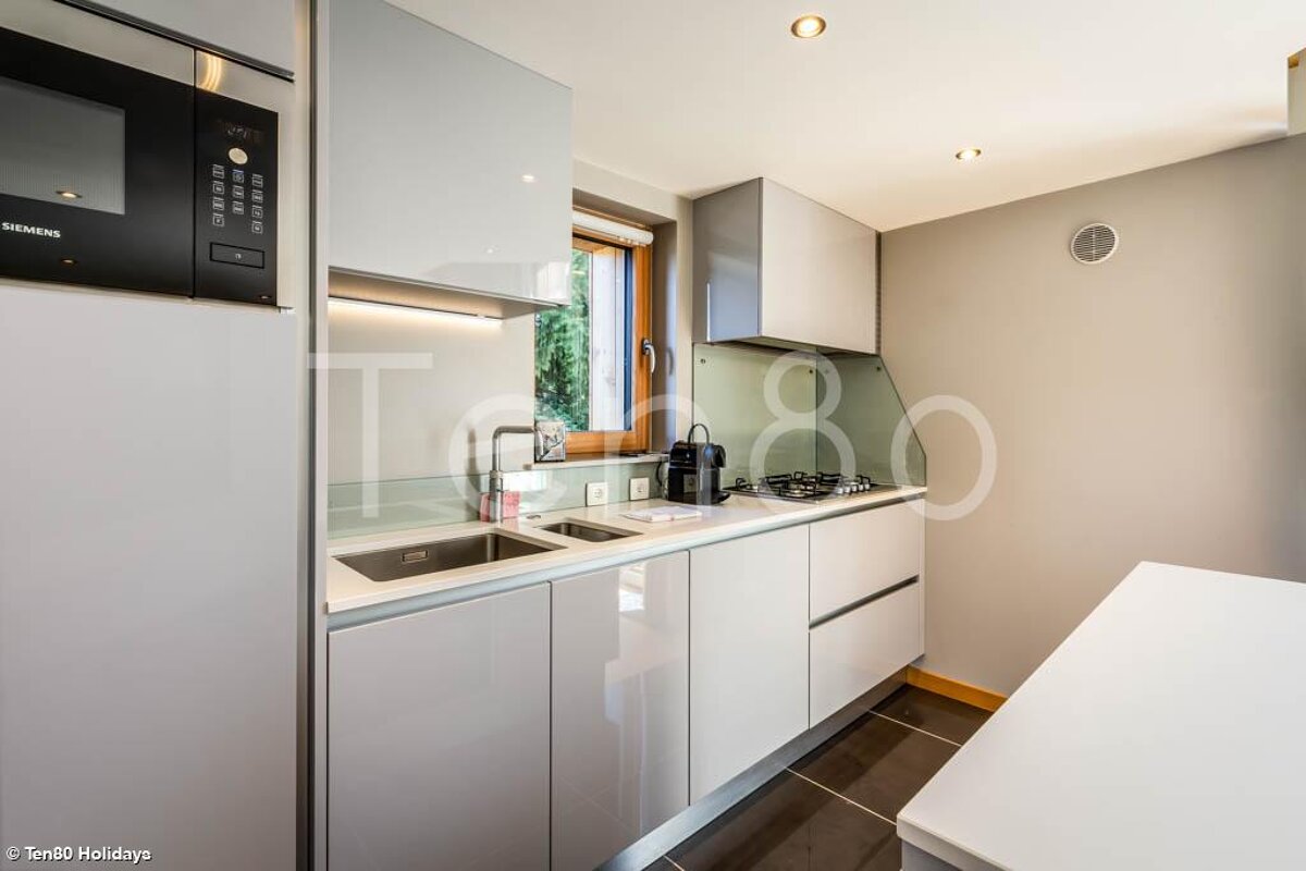 A kitchen with white cabinets and a siemens microwave