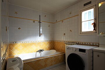 A bathroom with a bathtub and a washing machine