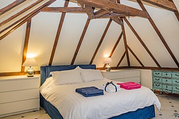 A bedroom with a bed and a dresser with a blue towel that says la riviere on it