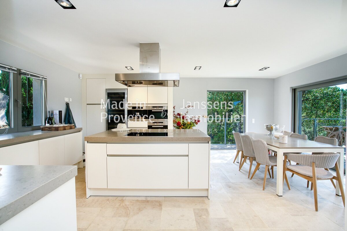 A kitchen with white cabinets and stainless steel appliances and the words made in provence