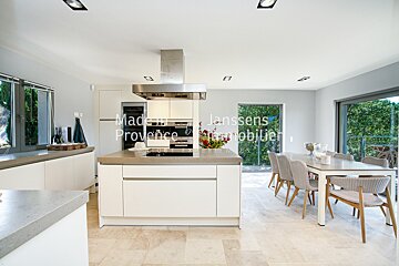 A kitchen with white cabinets and stainless steel appliances and the words made in provence