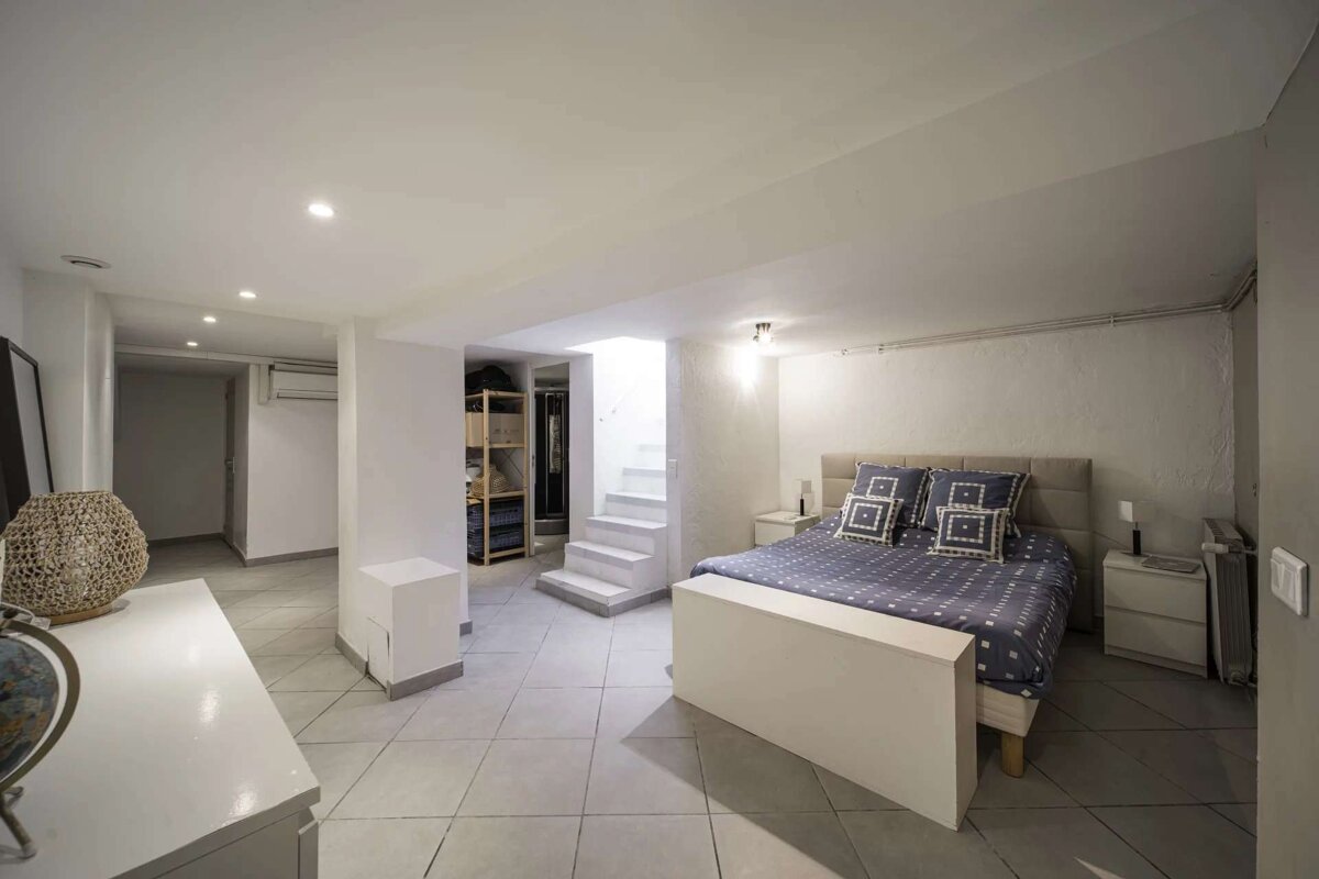 A bedroom with a blue and white bed and stairs
