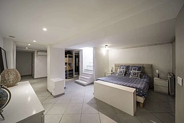 A bedroom with a blue and white bed and stairs