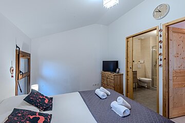 A bedroom with a bed and a clock on the wall