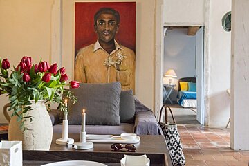 A living room with a painting of a man on the wall