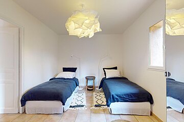 A bedroom with two beds and a mirror