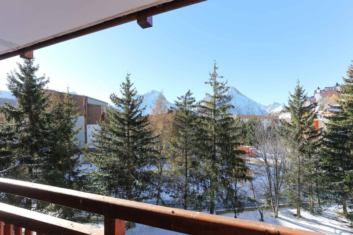 A balcony with trees and mountains in the background