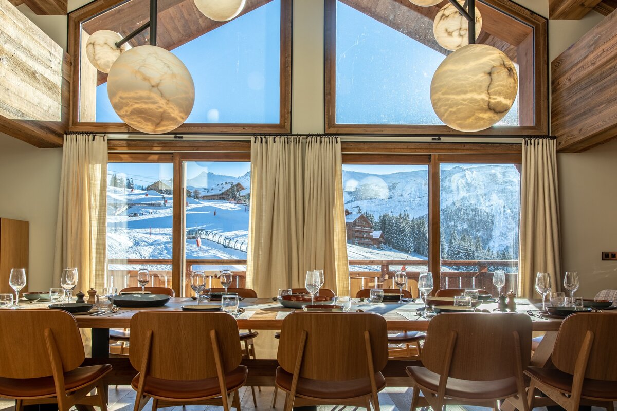 A dining room table with a view of a snowy mountain