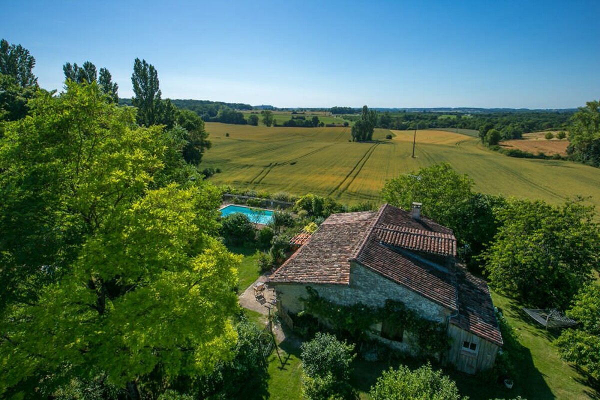 An aerial view of a house with a pool in the backyard