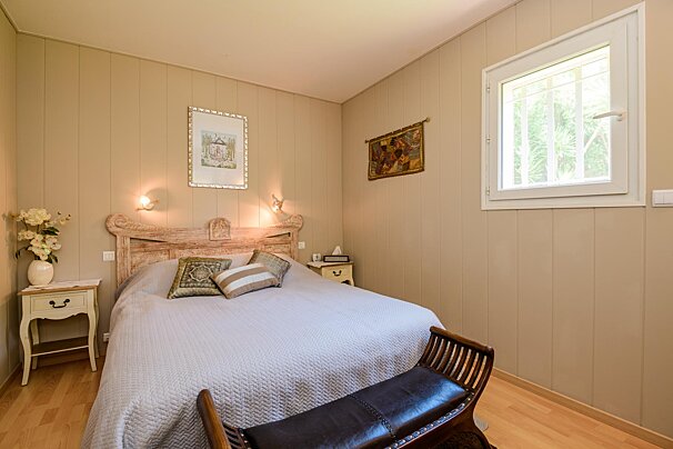 A bedroom with a bed a nightstand and a window