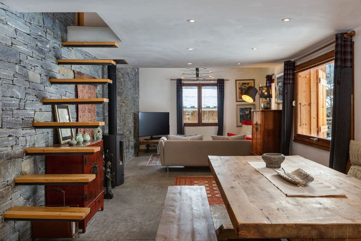 A living room with a wooden table and stairs