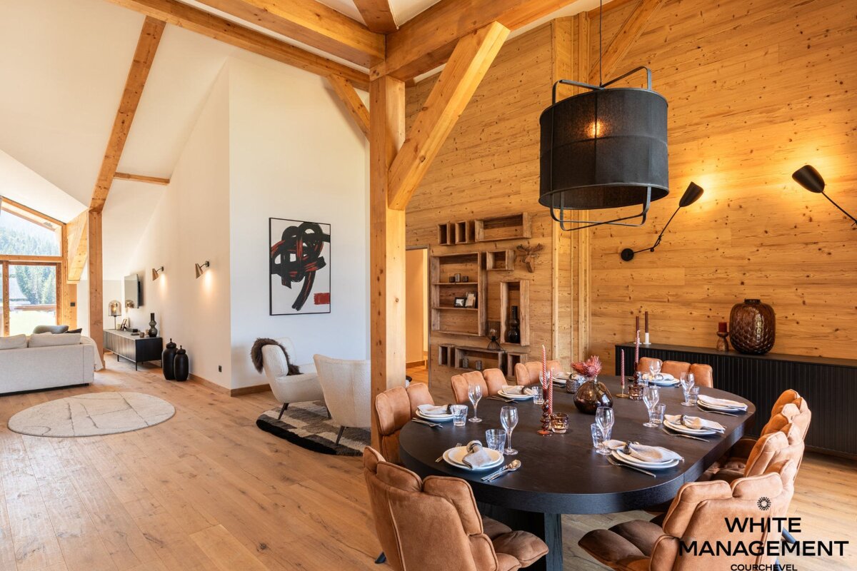 A white chair sits in a living room next to a window