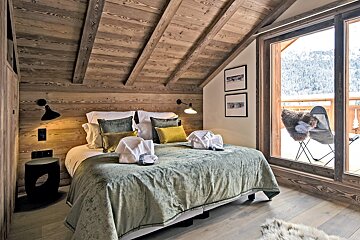 A bedroom with a large bed and a sliding glass door