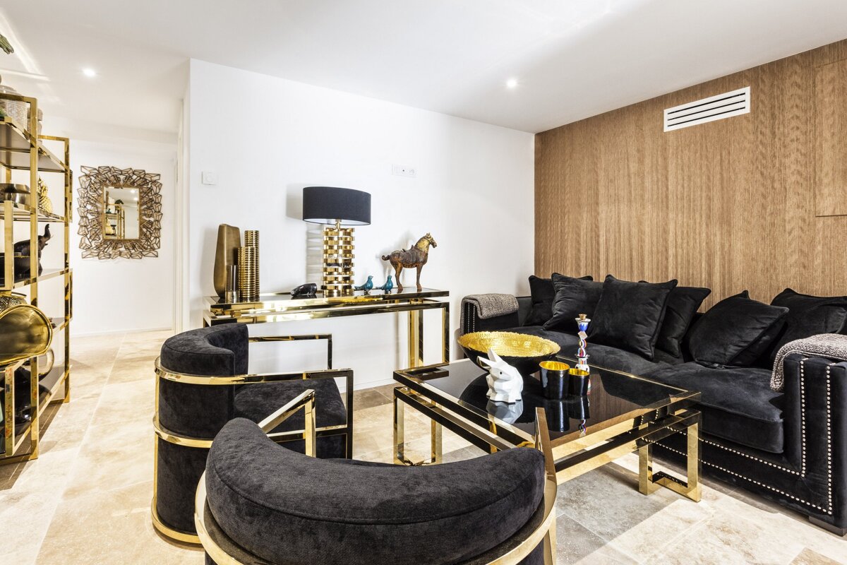 A living room with a black couch and black chairs