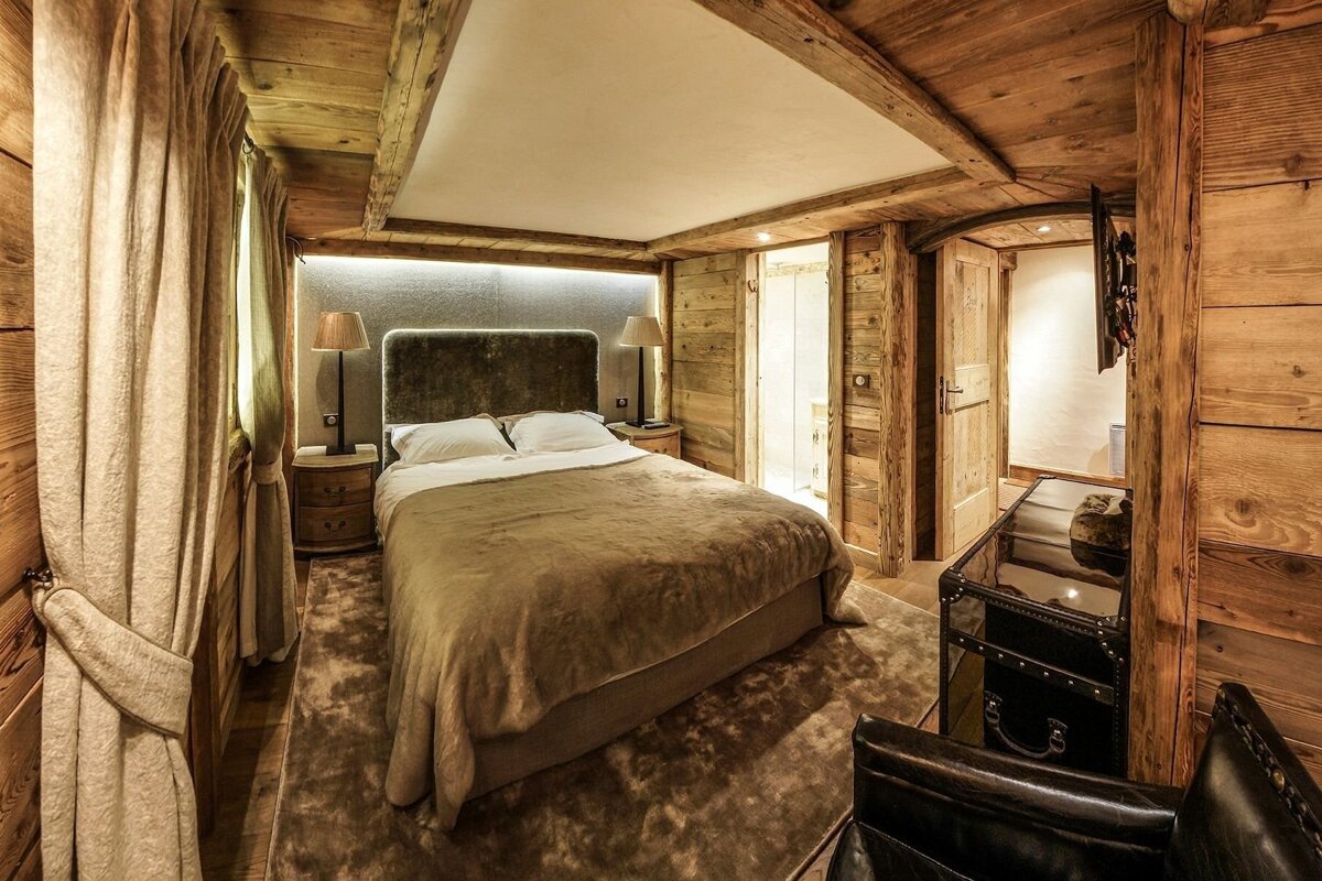 A bedroom with a bed and a trunk in the corner
