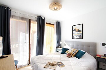 A bedroom with a bed and a picture on the wall