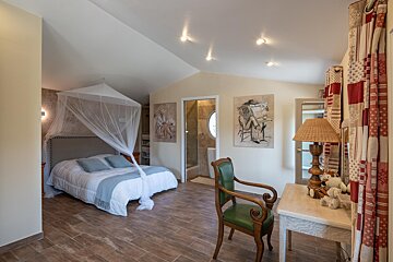 A bedroom with a canopy bed and a desk