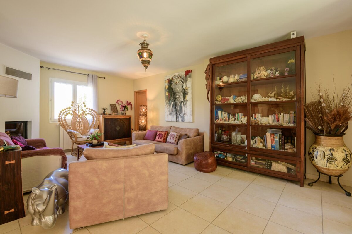 A living room with a couch a chair a bookcase and a painting of an elephant on the wall
