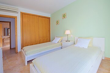 A bedroom with two twin beds and a closet